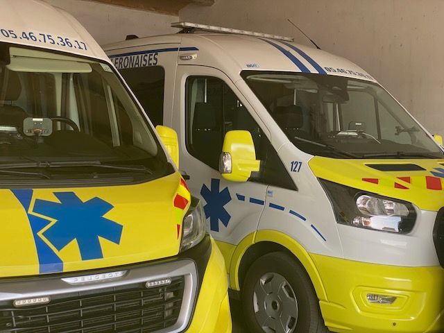 Deux ambulances jaunes et blanches étaient garées côte à côte à l'intérieur d'un bâtiment, chacune arborant une étoile bleue, symbole de vie.