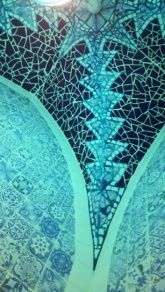 Techo de mosaico azul con patrones geométricos y acentos florales.