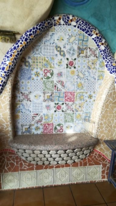 Un banco de mosaico con un fondo de mosaico arqueado decorativo.