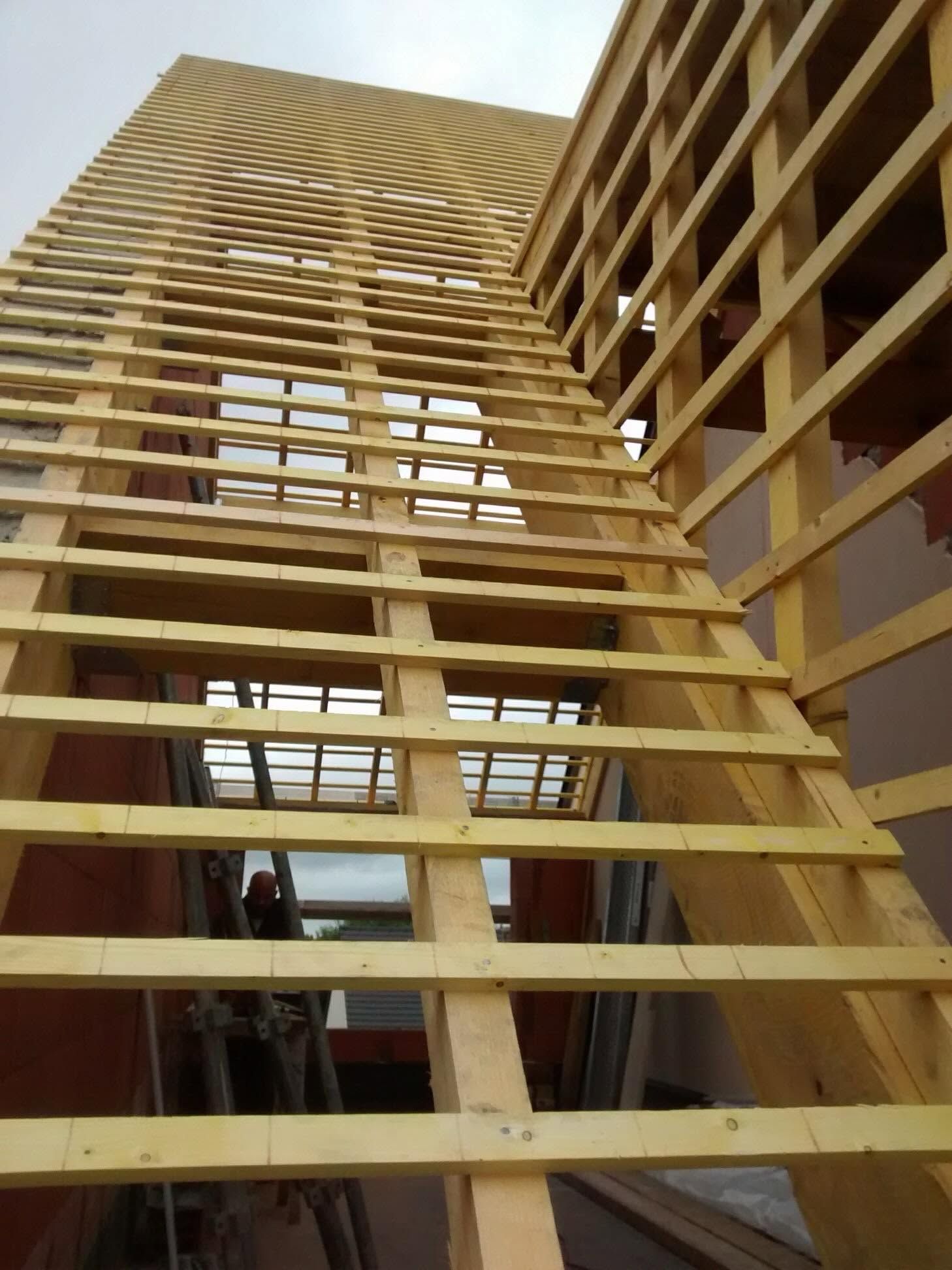 Vue en contre-plongée d'un escalier en bois à l'intérieur d'un bâtiment à ossature en bois en construction.