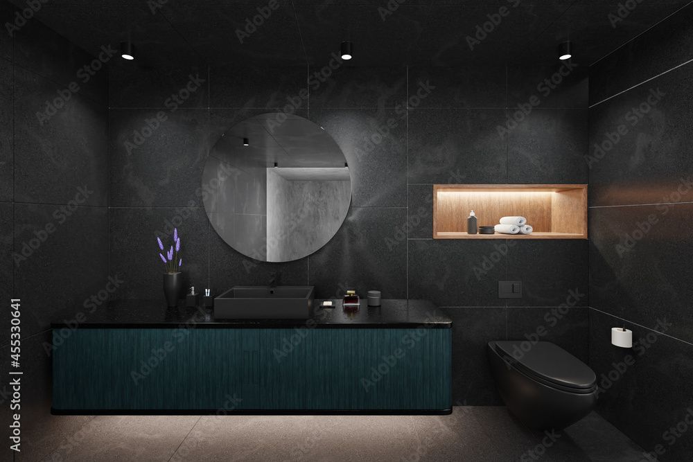 Modernes, dunkles Badezimmer mit türkisfarbenem Waschtisch, rundem Spiegel und schwarzer Toilette.