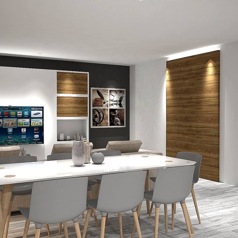 Un comedor con una mesa larga y sillas y un televisor de pantalla plana.