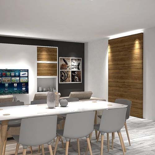 Un comedor con una mesa larga y sillas y un televisor de pantalla plana.