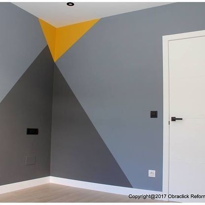 Una habitación con un diseño geométrico en la pared y una puerta.