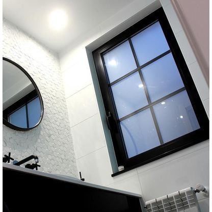 Un baño con lavabo, espejo y ventana.
