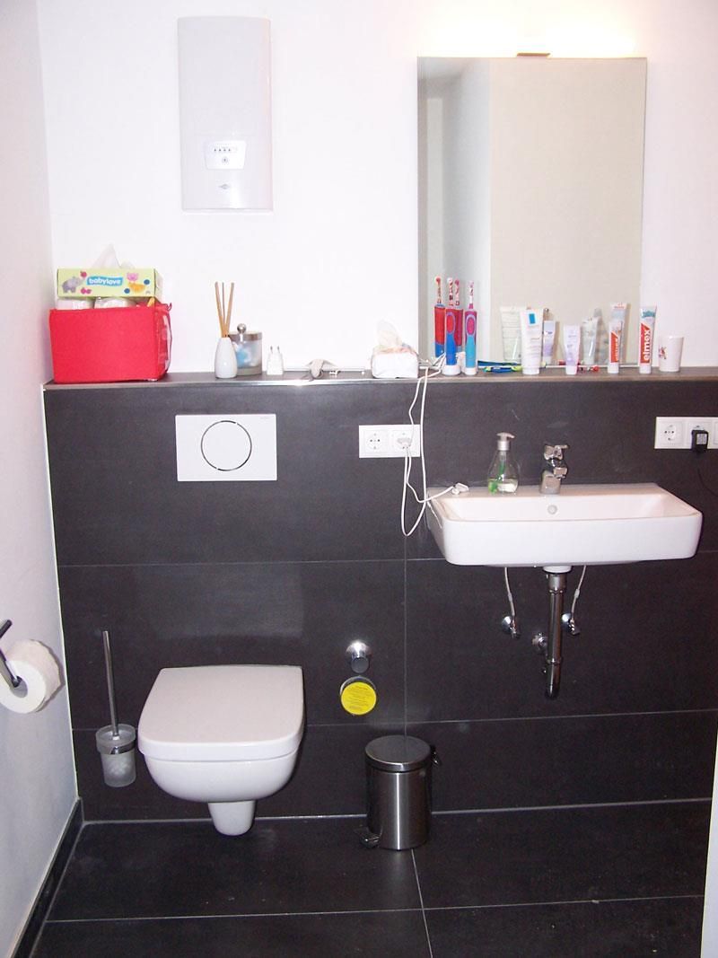 Ein Badezimmer mit Toilette, Waschbecken und Spiegel