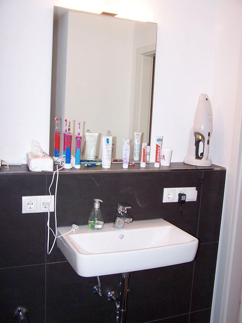 Ein Badezimmer mit einem Waschbecken und einem Spiegel mit dem Buchstaben P darauf