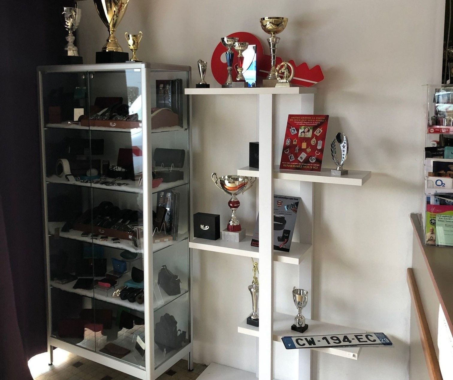 Gros plan sur une étagère avec les coupes, médailles et plaques gravées.