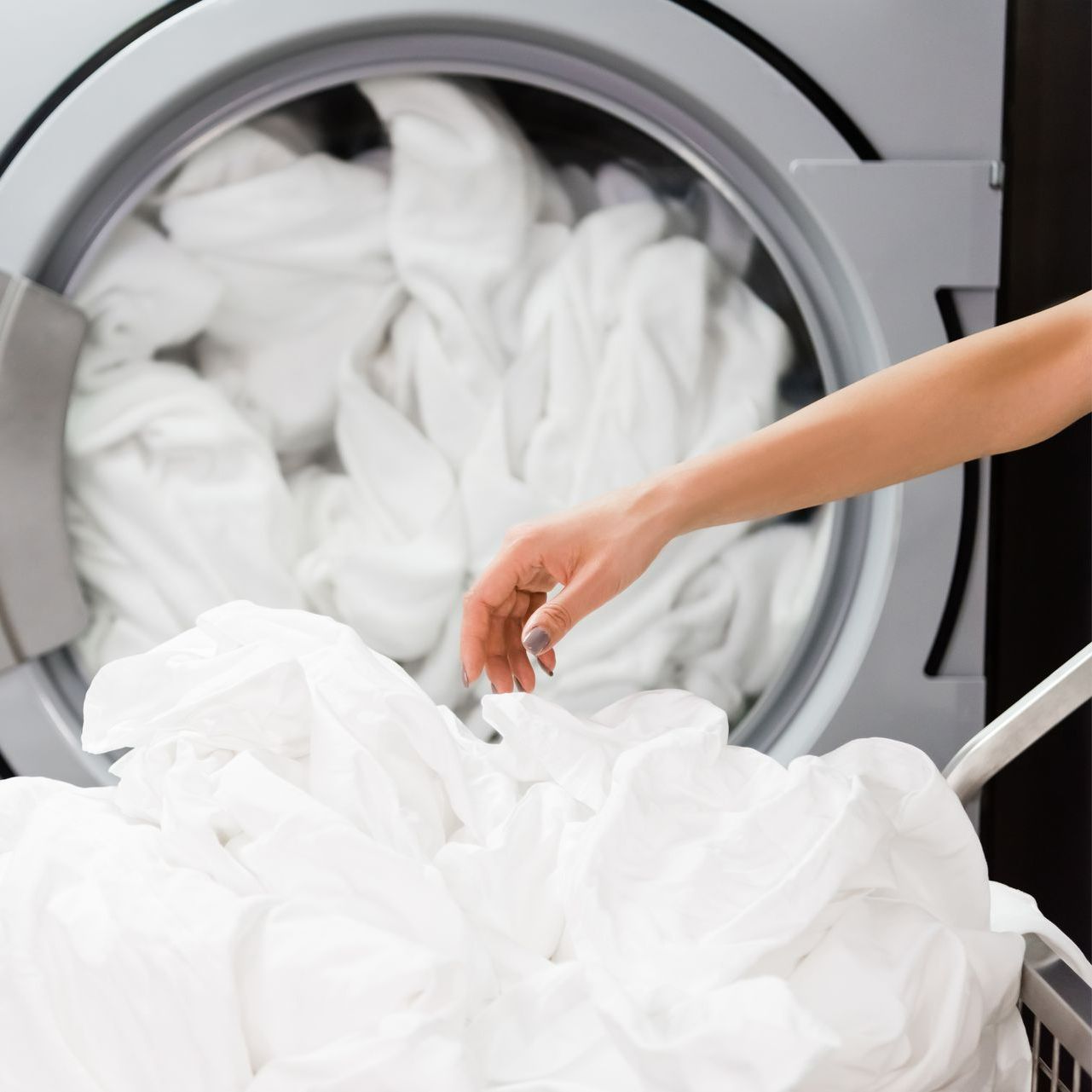 Un tas de linge avec une machine à laver en arrière-plan.