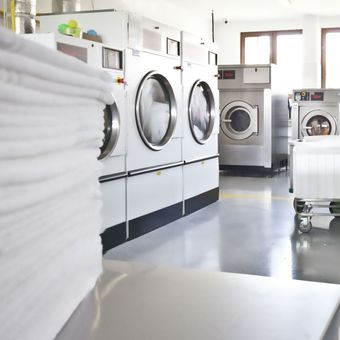 Les machines à laver avec du linge propre en premier plan.