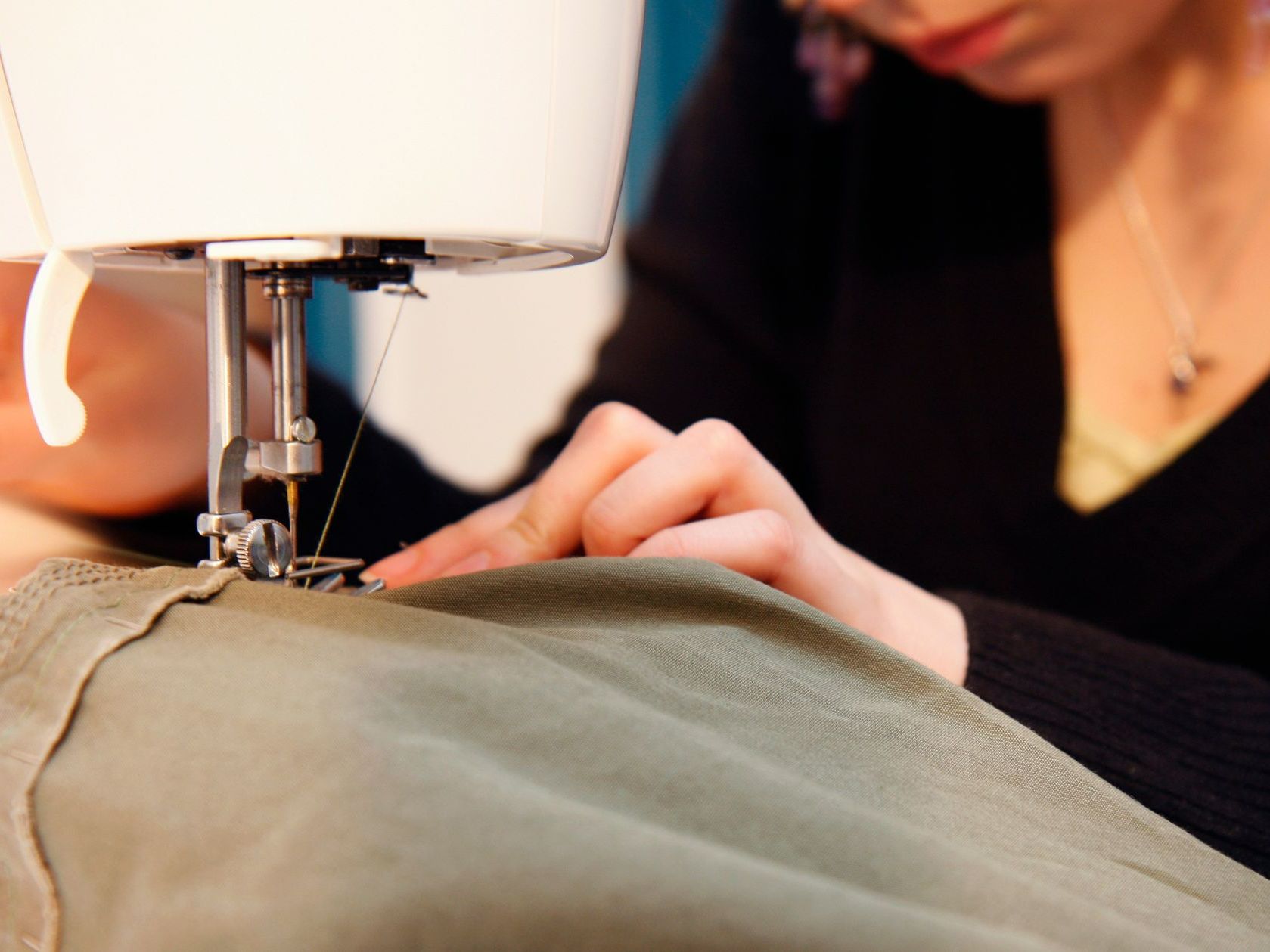 Une femme qui est en train de faire de la couture.