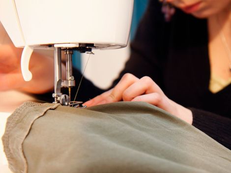 Une femme qui est en train d'utiliser la machine à coudre.
