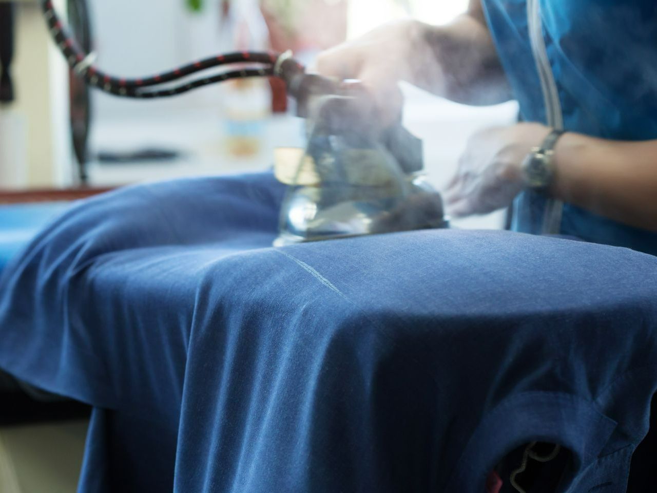 Une personne avec le fer à repasser.