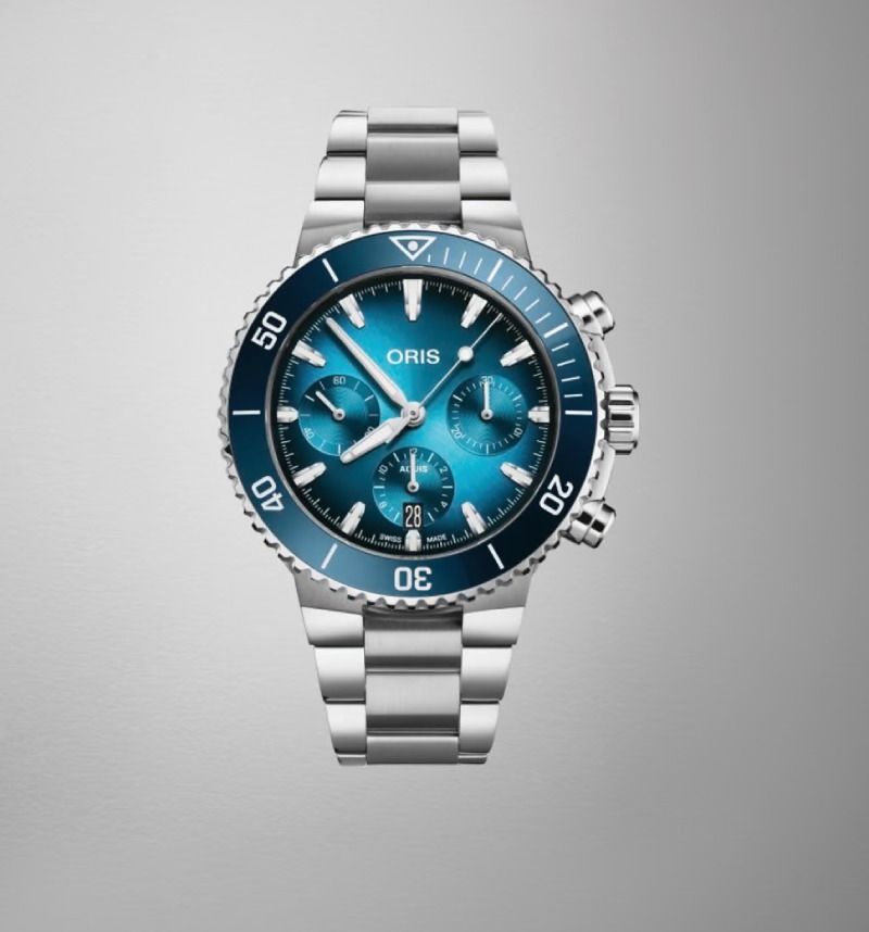 Blaue Oris Chronographen-Armbanduhr mit Edelstahlarmband auf grauem Hintergrund