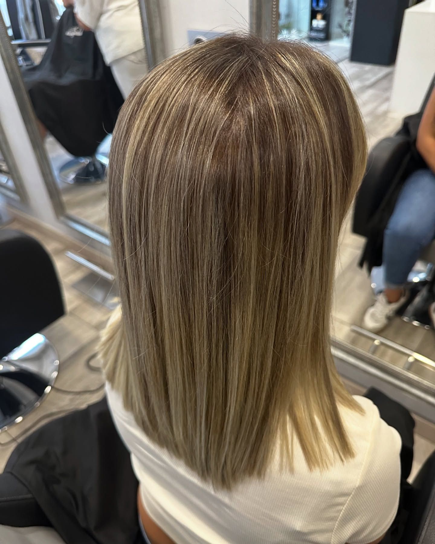 Una mujer está sentada en una silla con su cabello en un salón.