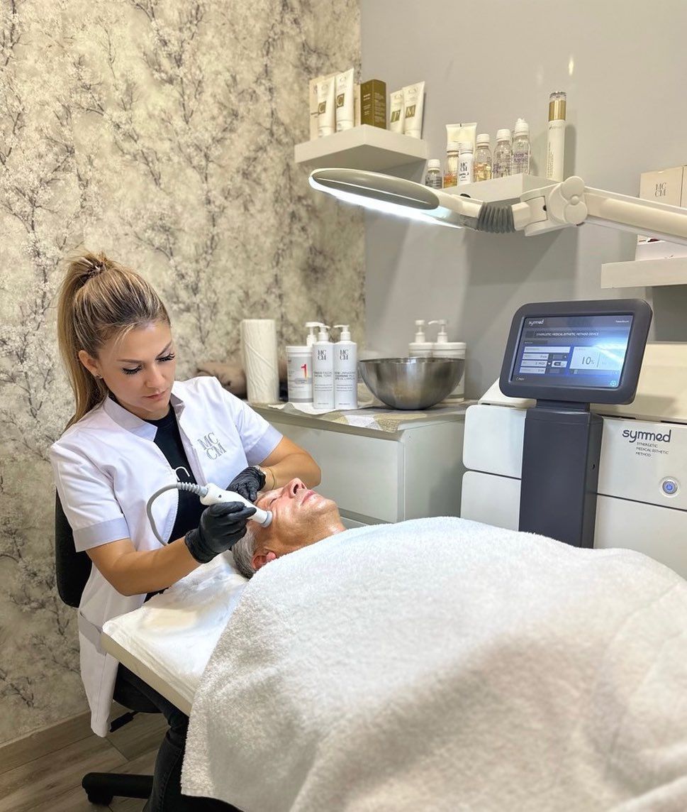 Una mujer le está dando a un hombre un tratamiento facial en un salón de belleza.