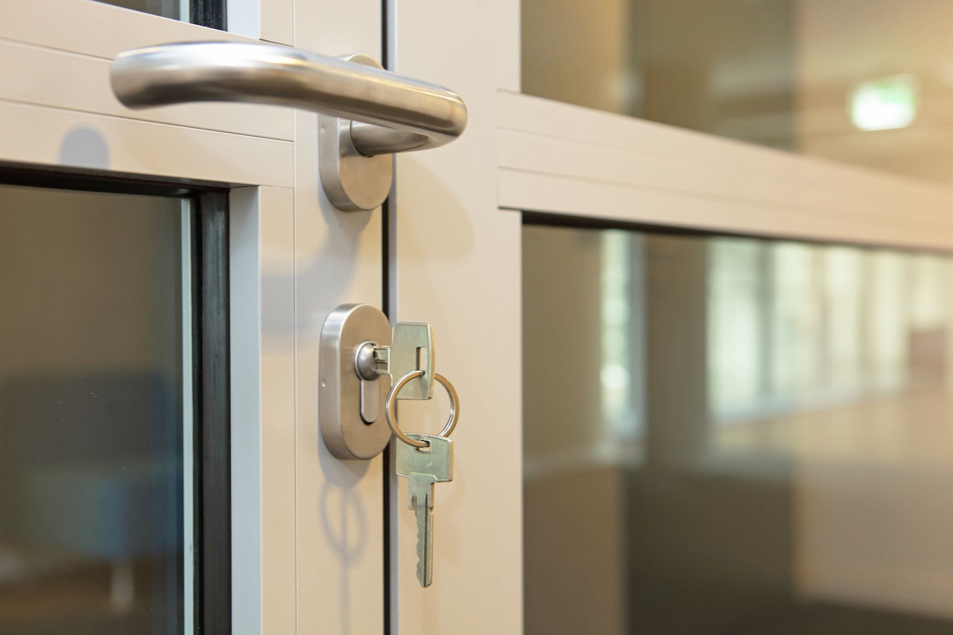 Gros plan d'une clé dans la serrure d'une porte de bureau vitrée