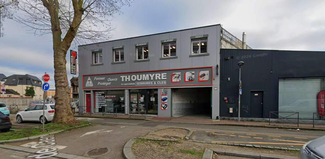Façade de magasin avec enseigne rouge sur un bâtiment gris