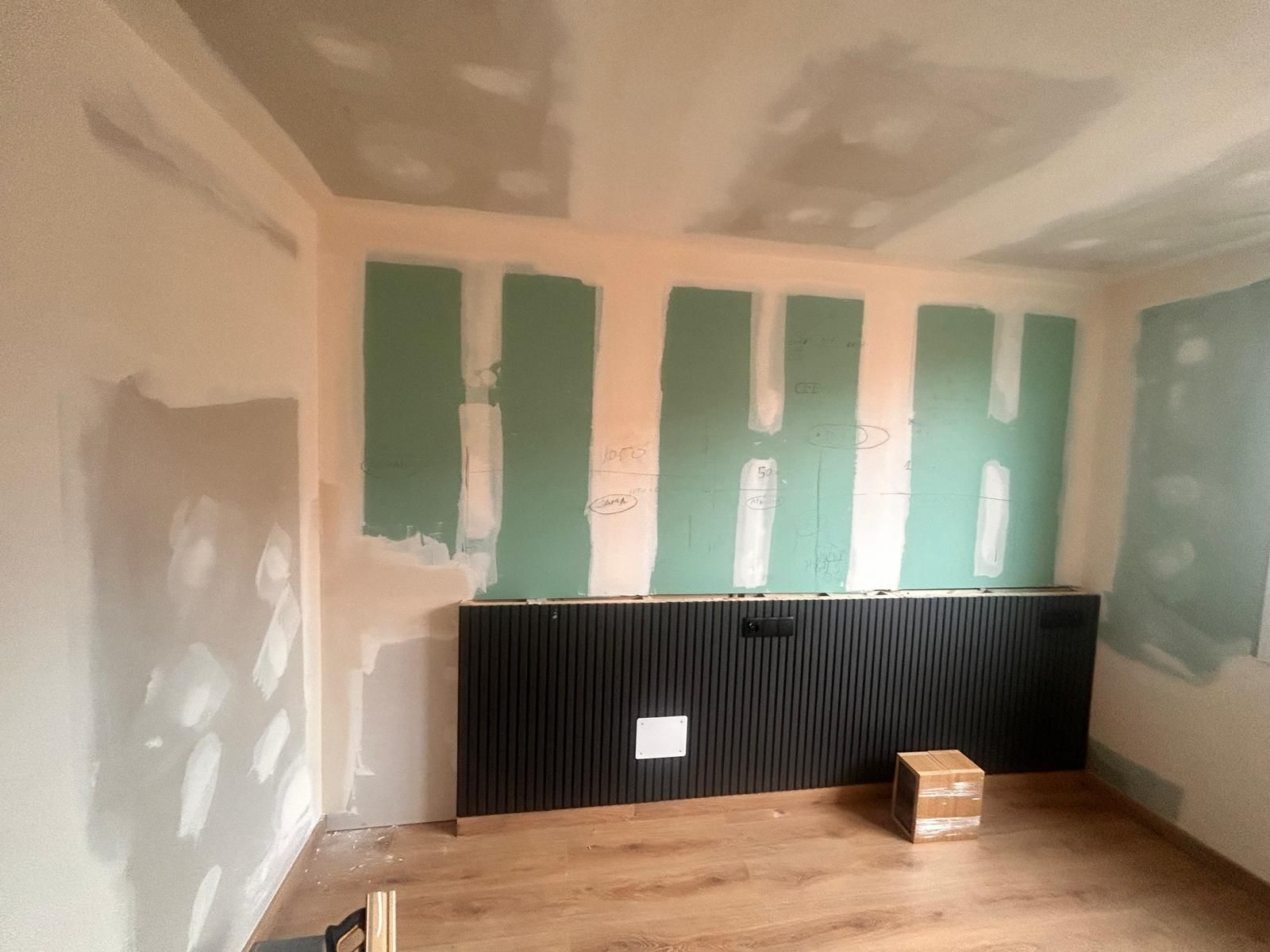 Una habitación con piso de madera y techo que está siendo remodelada.