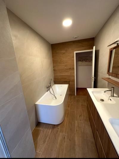 Salle de bains moderne avec baignoire îlot, meuble double vasque et parquet en bois