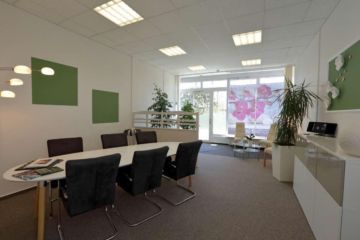 Ein großer Raum mit einem Tisch und Stühlen darin.