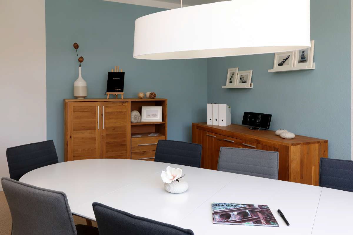 Ein Konferenzraum mit einem langen weißen Tisch und Stühlen.