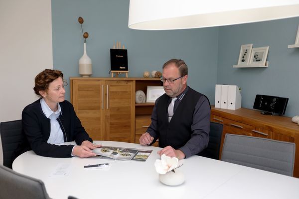 Ein Mann und eine Frau sitzen an einem Tisch und betrachten ein Bild