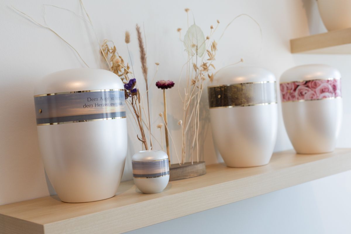 Ein Regal mit Urnen und Blumen darauf.