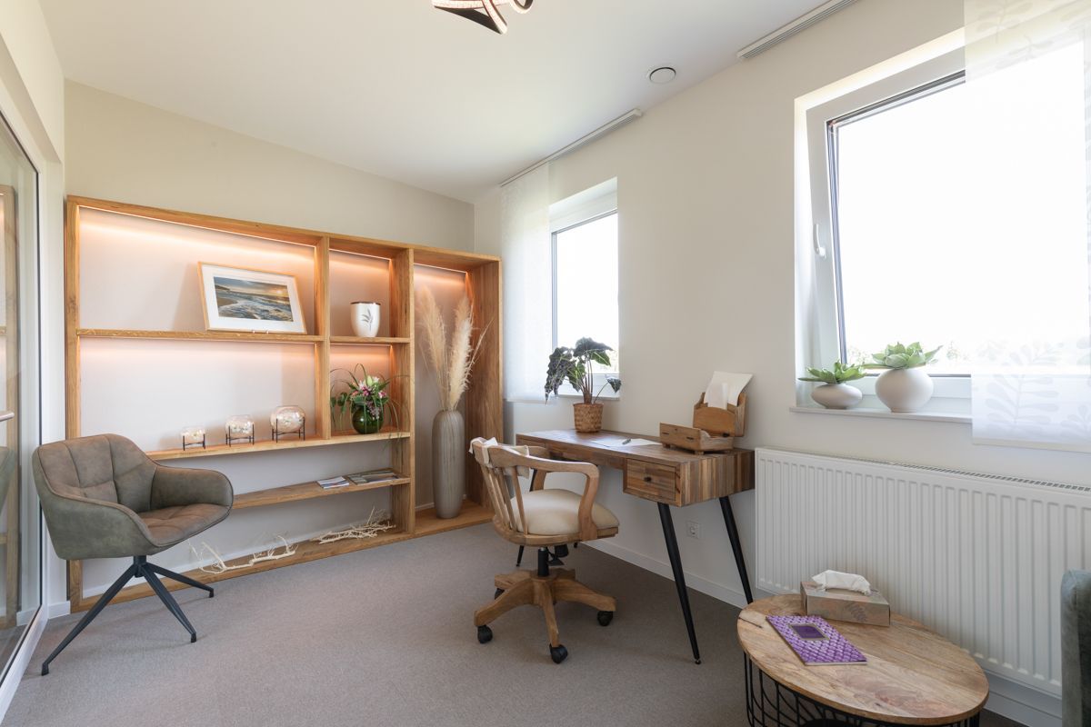 Ein Zimmer mit Schreibtisch, Stuhl und Couchtisch.