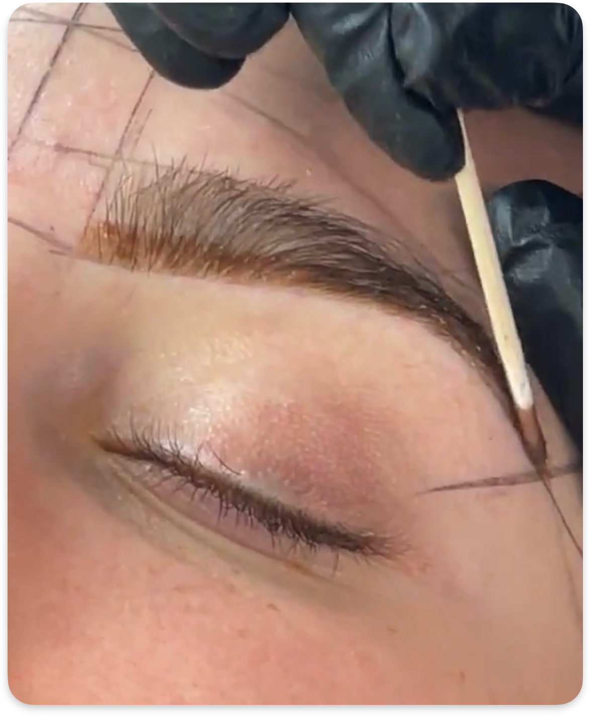 Una persona está midiendo las cejas de una mujer con un lápiz.