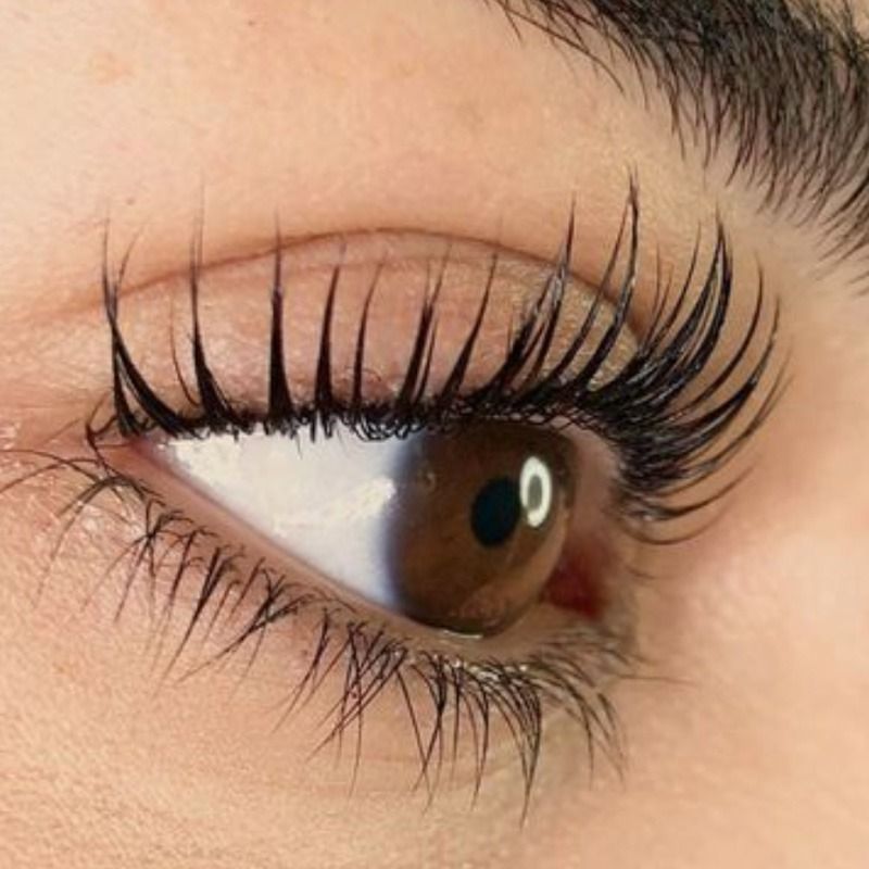 Un primer plano del ojo de una mujer con pestañas largas.
