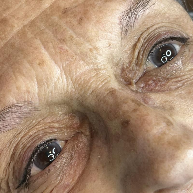 Un primer plano del rostro y los ojos de una mujer mayor.