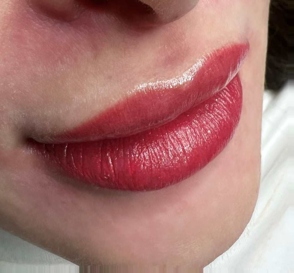 Un primer plano de los labios de una mujer con lápiz labial rojo.