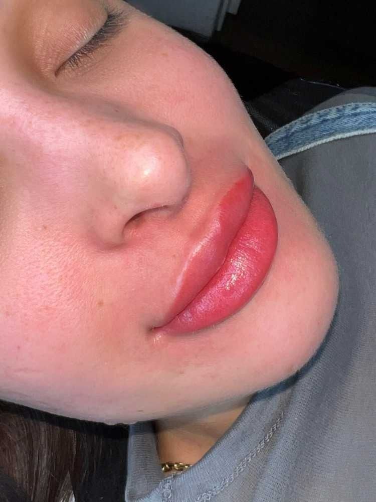Un primer plano de los labios de una mujer con lápiz labial rojo.