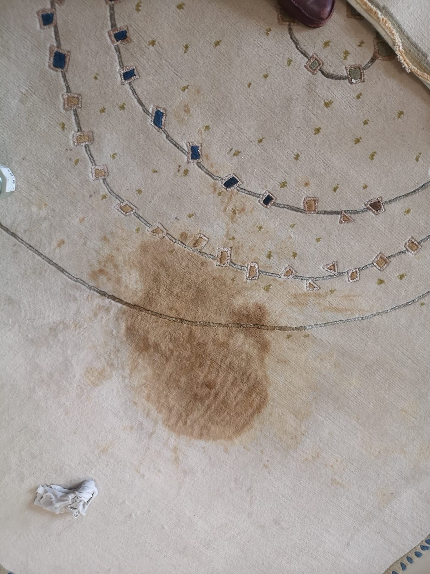 Un tapis décoratif  taché avec une tache brune.