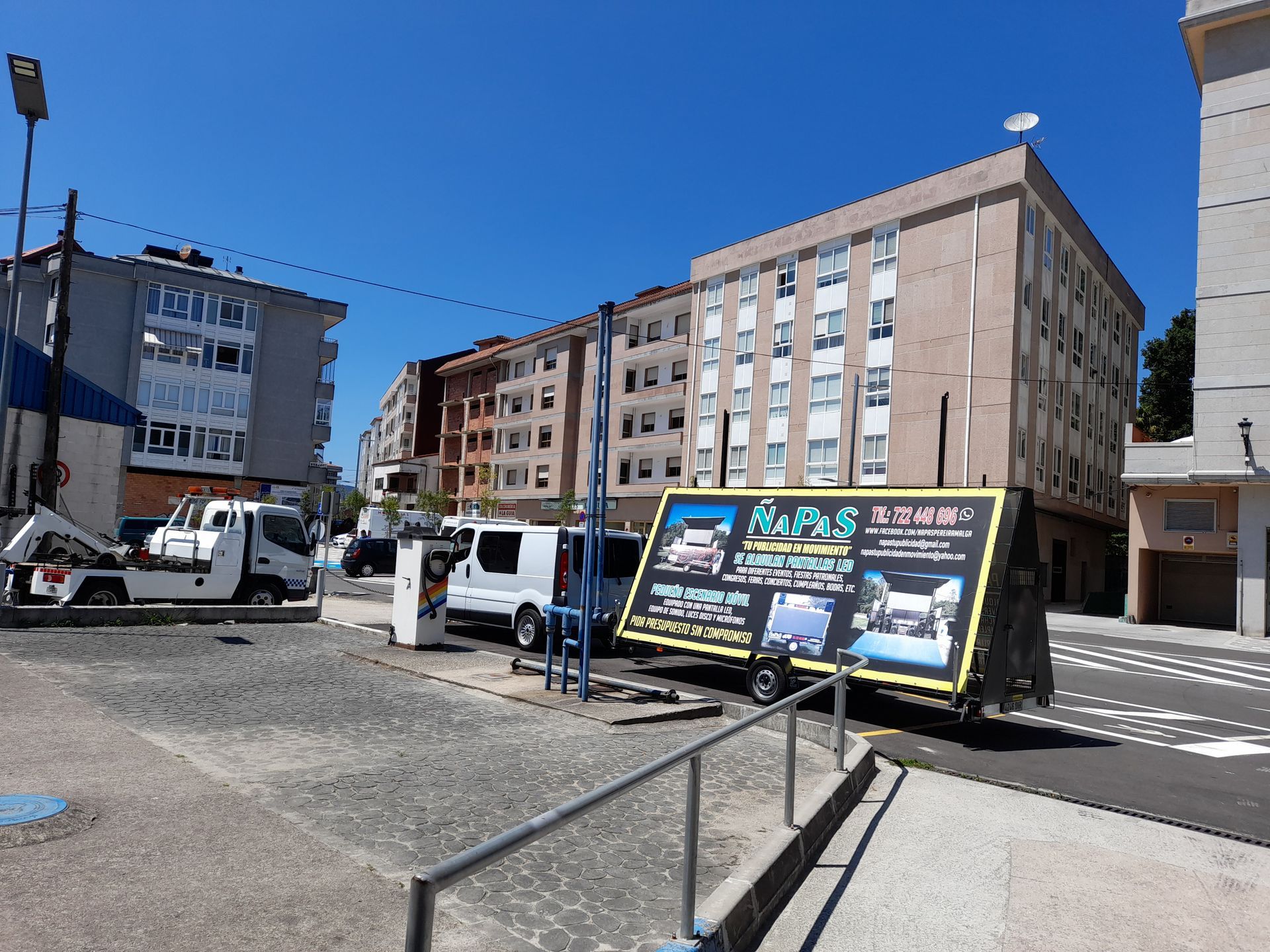 Un remolque con un cartel está estacionado frente a un edificio.