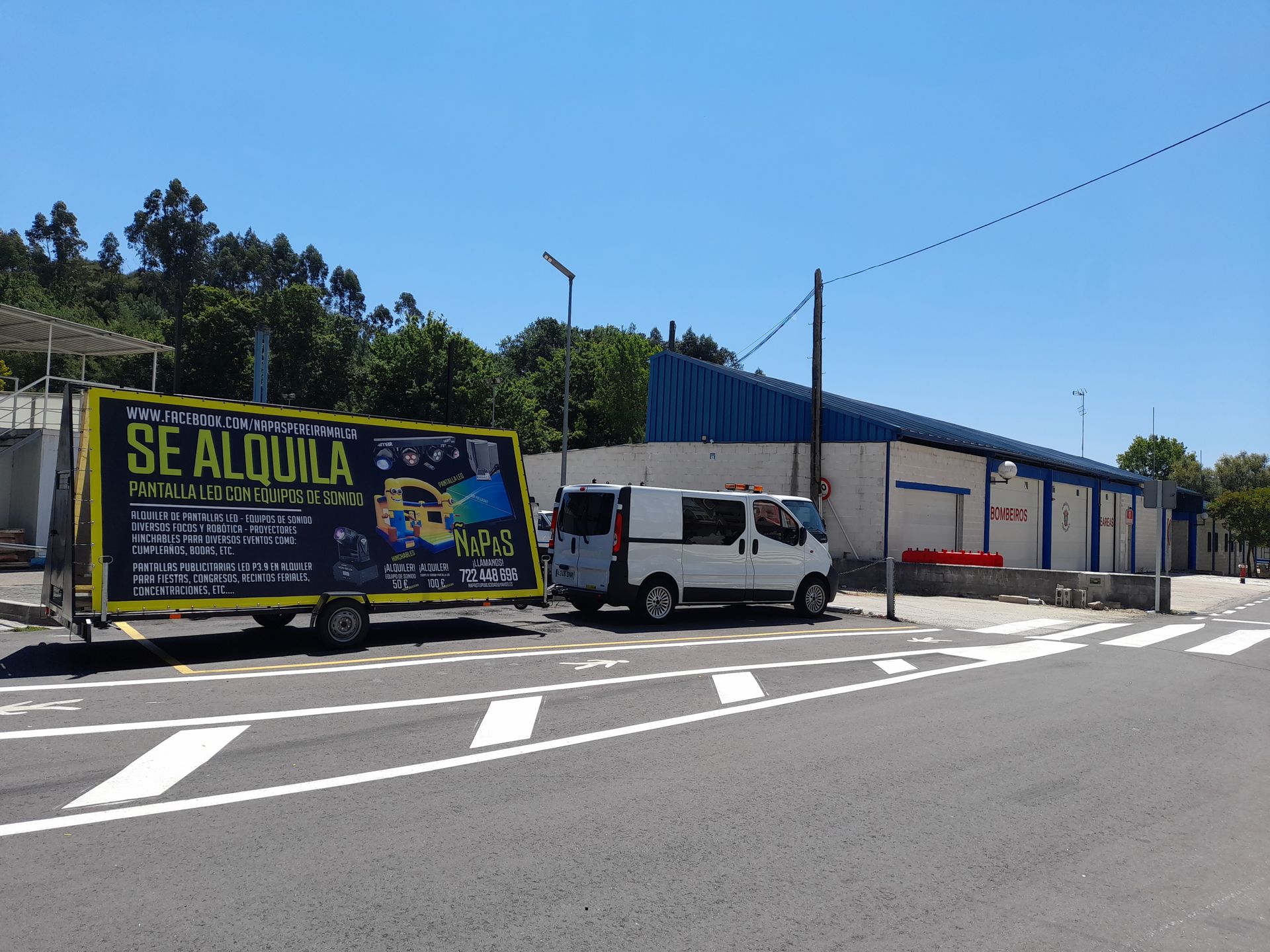 Una camioneta blanca está estacionada junto a un cartel amarillo que dice se alquila