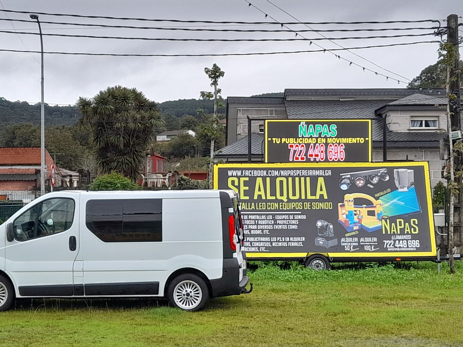 Una furgoneta blanca está aparcada junto a un cartel que dice se alquila