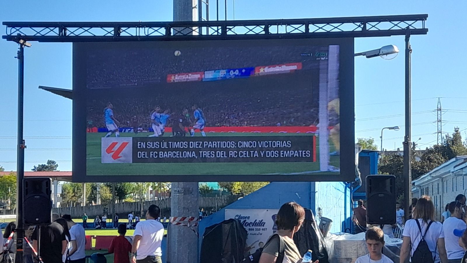 Un grupo de personas está de pie frente a una pantalla grande.