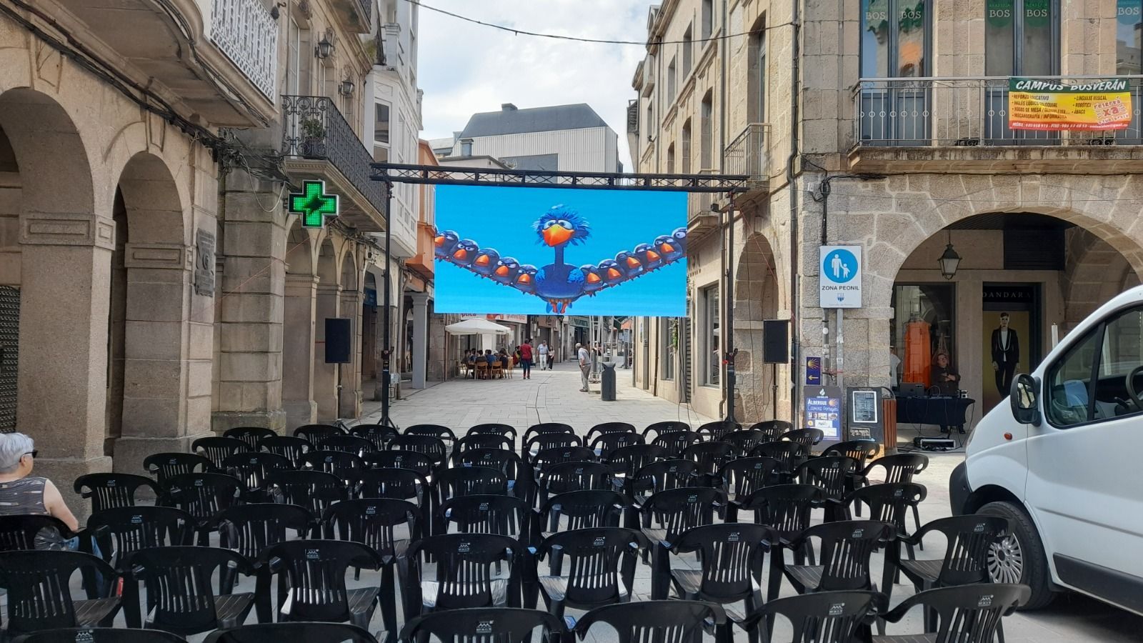 Una camioneta blanca está estacionada frente a una fila de sillas.