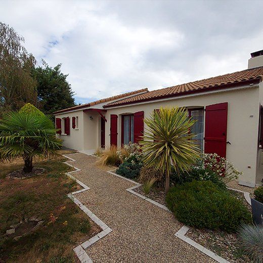 Rénovation extérieure d'une maison aux volets rouges.