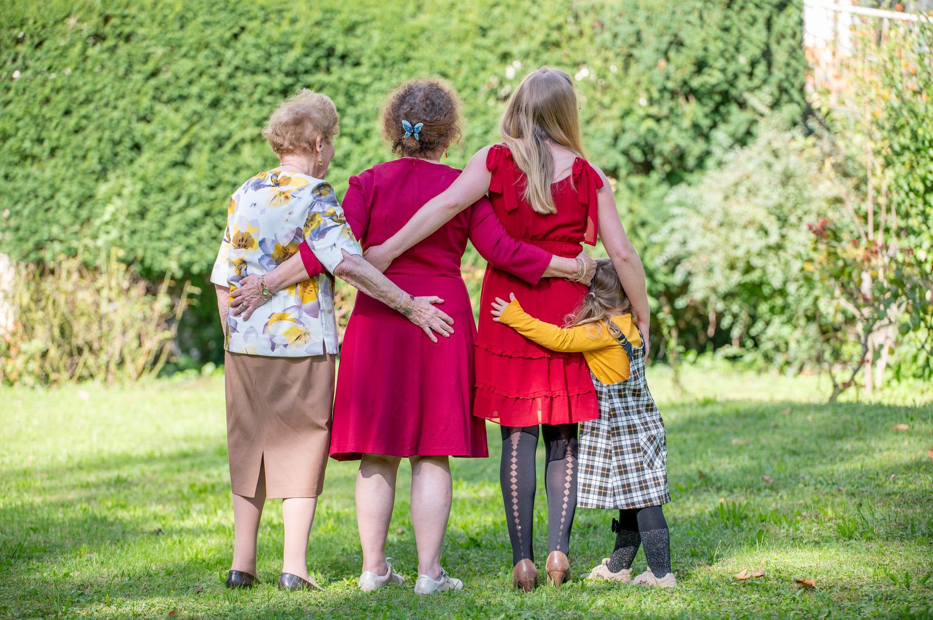 Trois femmes souriantes et enlacées sur fond jaune.