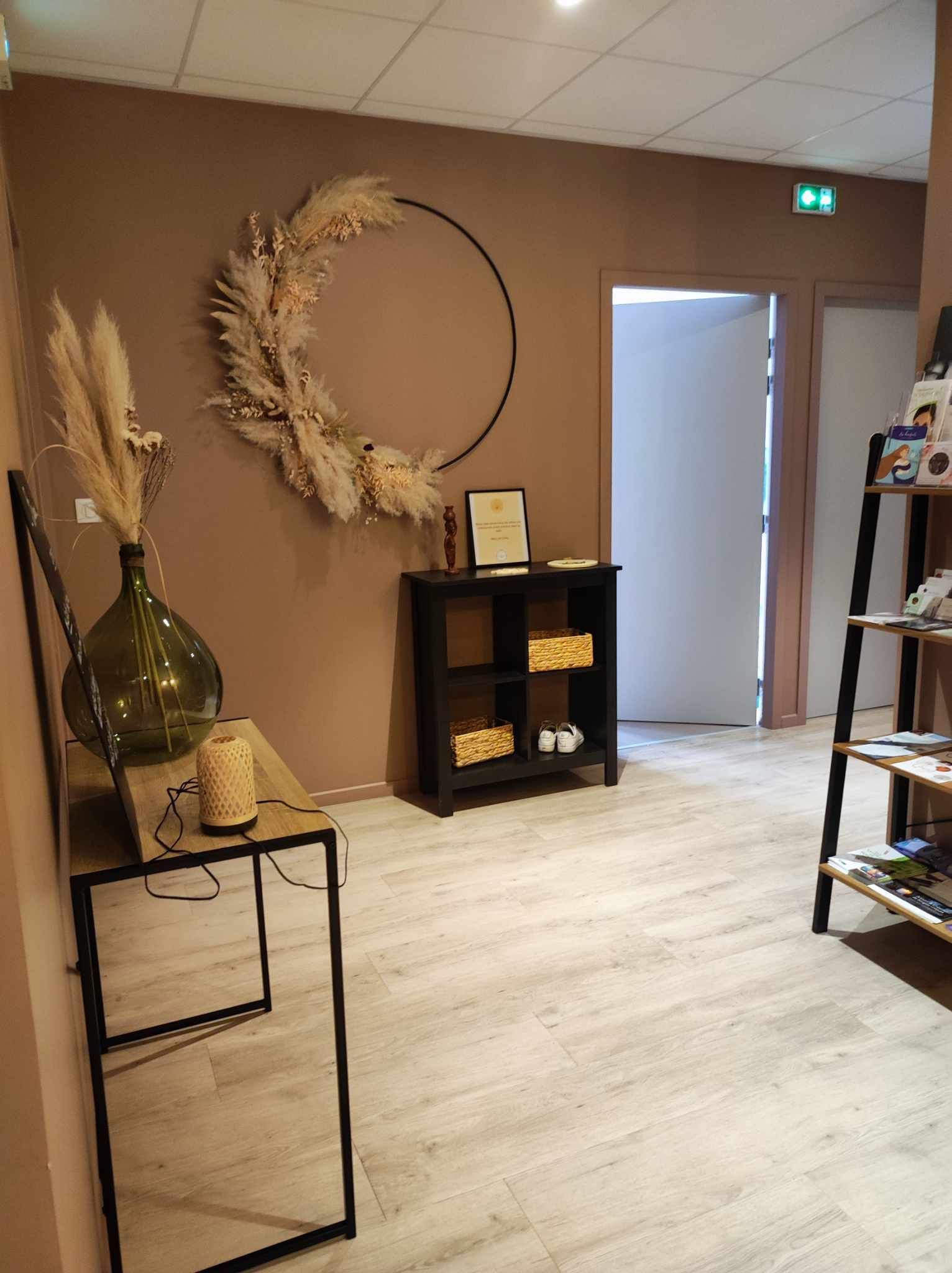Un intérieur accueillant avec une décoration murale florale, une étagère noire et un parquet.