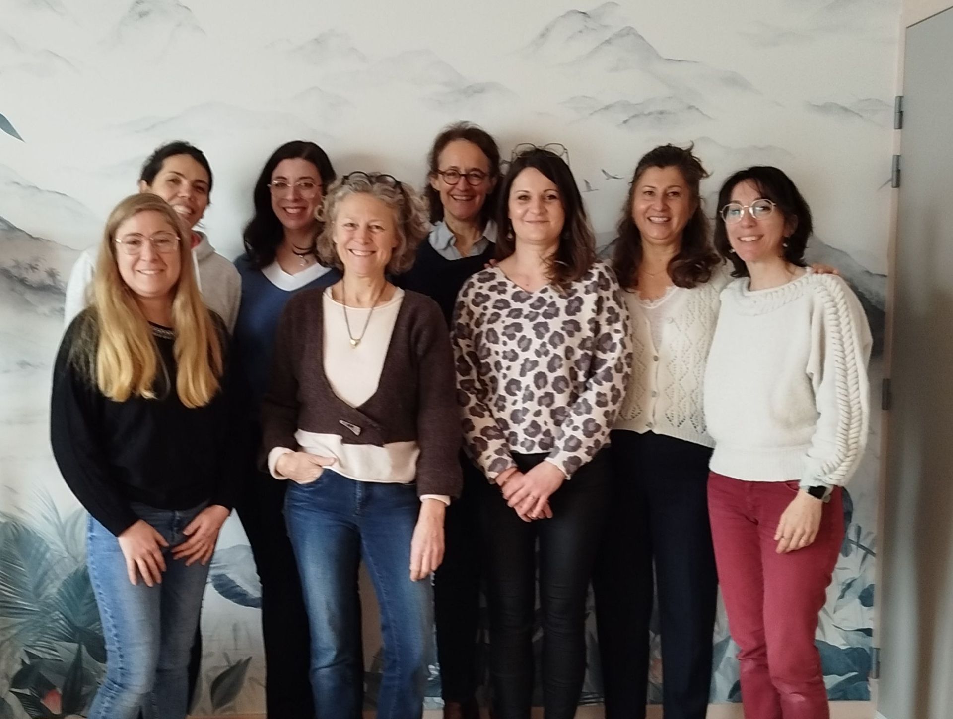 Groupe de femmes souriantes, debout ensemble, photo en médaillon d'une femme portant des lunettes.