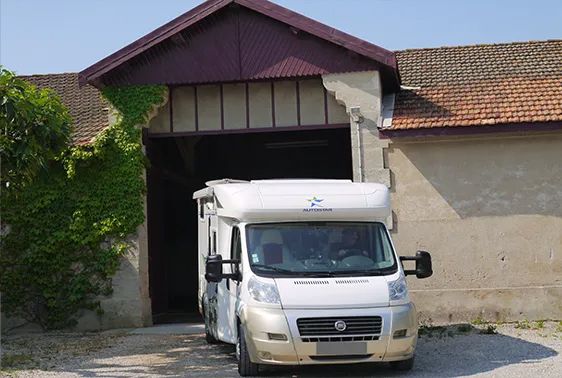 Camping-car garé devant un garage