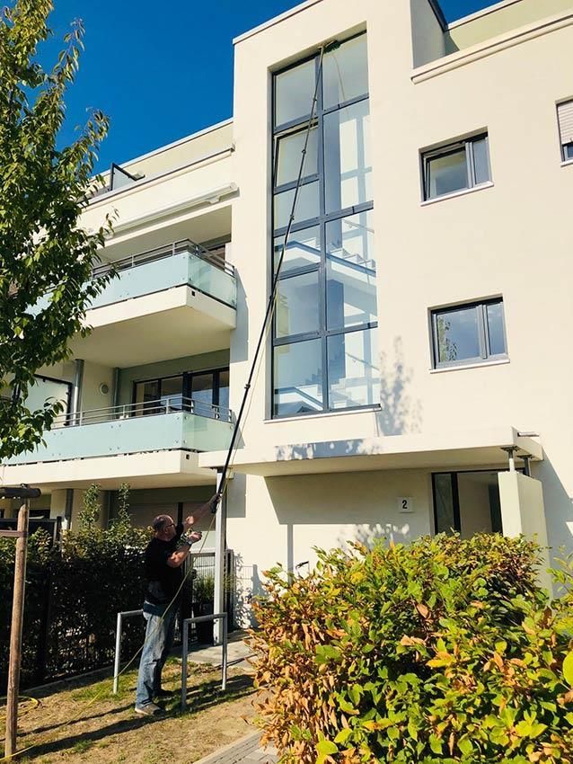 Ein Mann putzt die Fenster eines Gebäudes