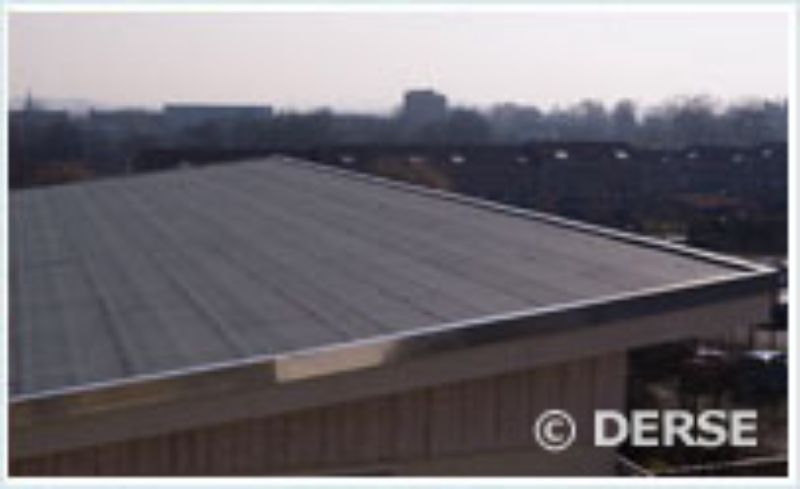 Eine leicht schräge Ansicht eines flachen, dunkelgrauen Daches mit metallisch glänzenden Kanten.