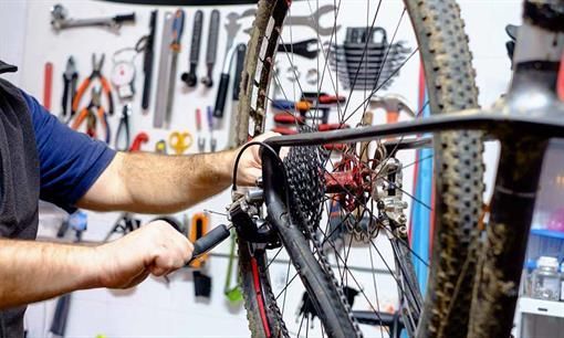 Ein Mann arbeitet in einer Werkstatt an einem Fahrrad.