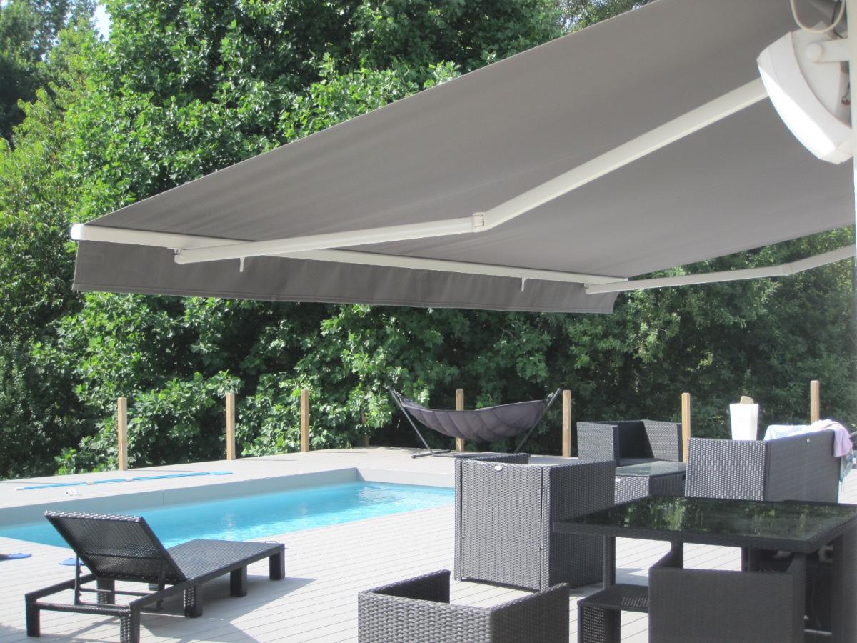Store gris déplié donnant sur une piscine