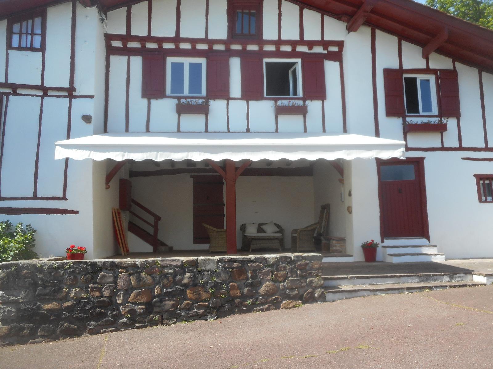 Store blanc sur une façade blanche et rouge